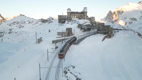 scenic aerial view of train arriving at gornergrat observation platform on beautiful winter day