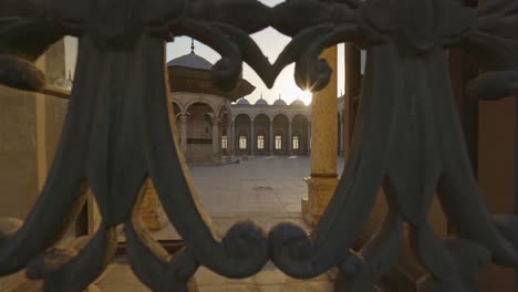 sun breaks through the lattice of window in the mosque muhammad ali pasha, courtyard is visible inside. great mosque of muhammad ali pasha or alabaster mosque in cairo, egypt.  citadel of cairo. gimbal shot, uhd 4k