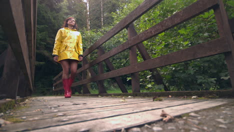 Attractive-brunette-walking-over-wooden-bridge