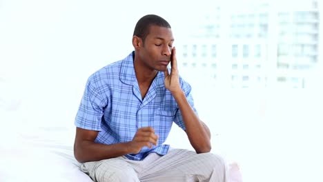 Hungover-man-sitting-on-the-end-of-his-bed