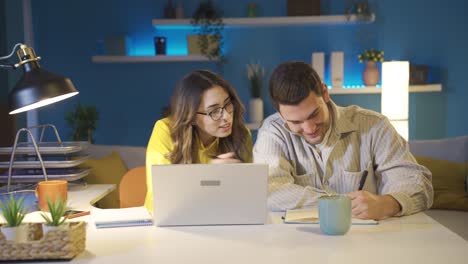 Happy-couple-working-together-in-home-office.