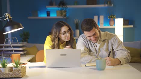 una pareja feliz trabajando juntos en una oficina en casa.