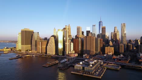vista aérea ascendente frente al horizonte iluminado de la hora dorada del bajo manhattan, nueva york