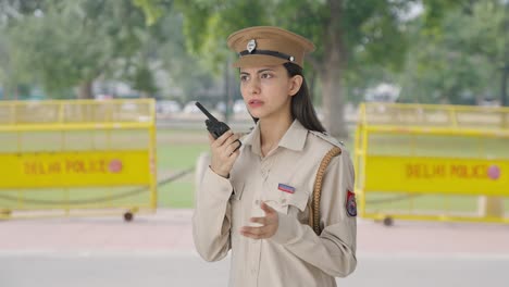 indian female police officer talking on walkie talkie