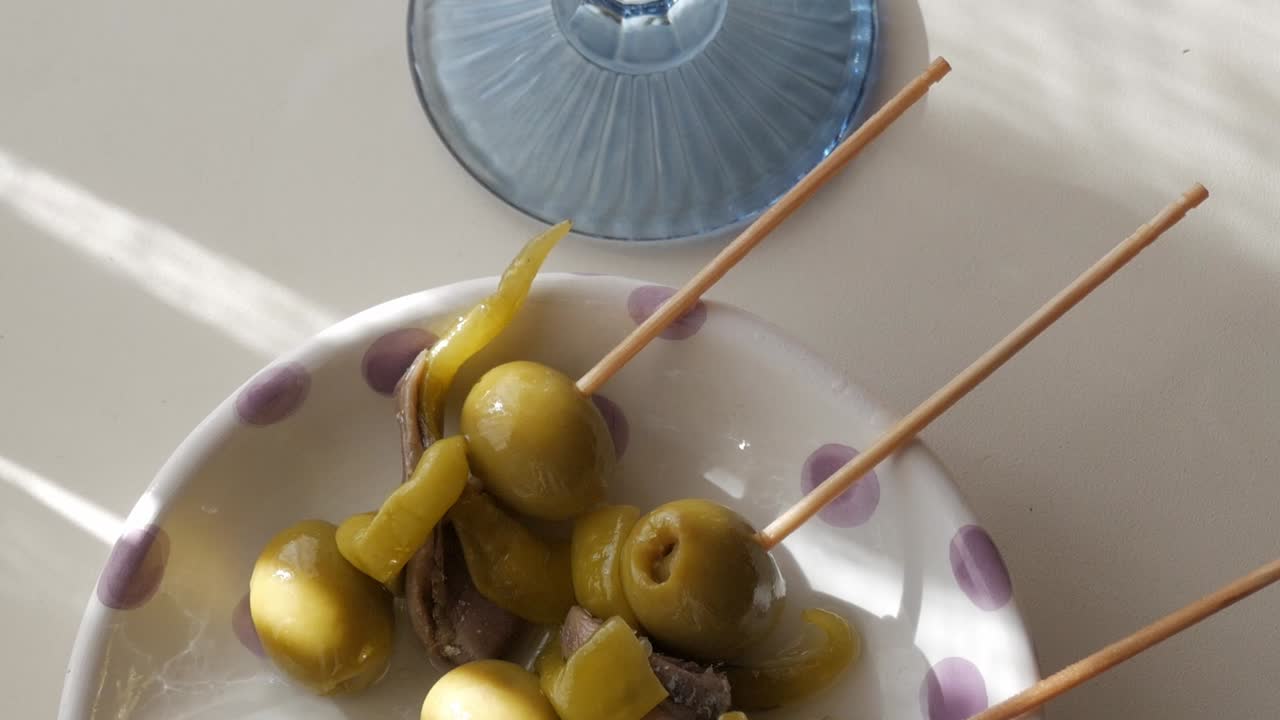 Gildas tapas served with vermouth, skewered olives, anchovies, and pickles