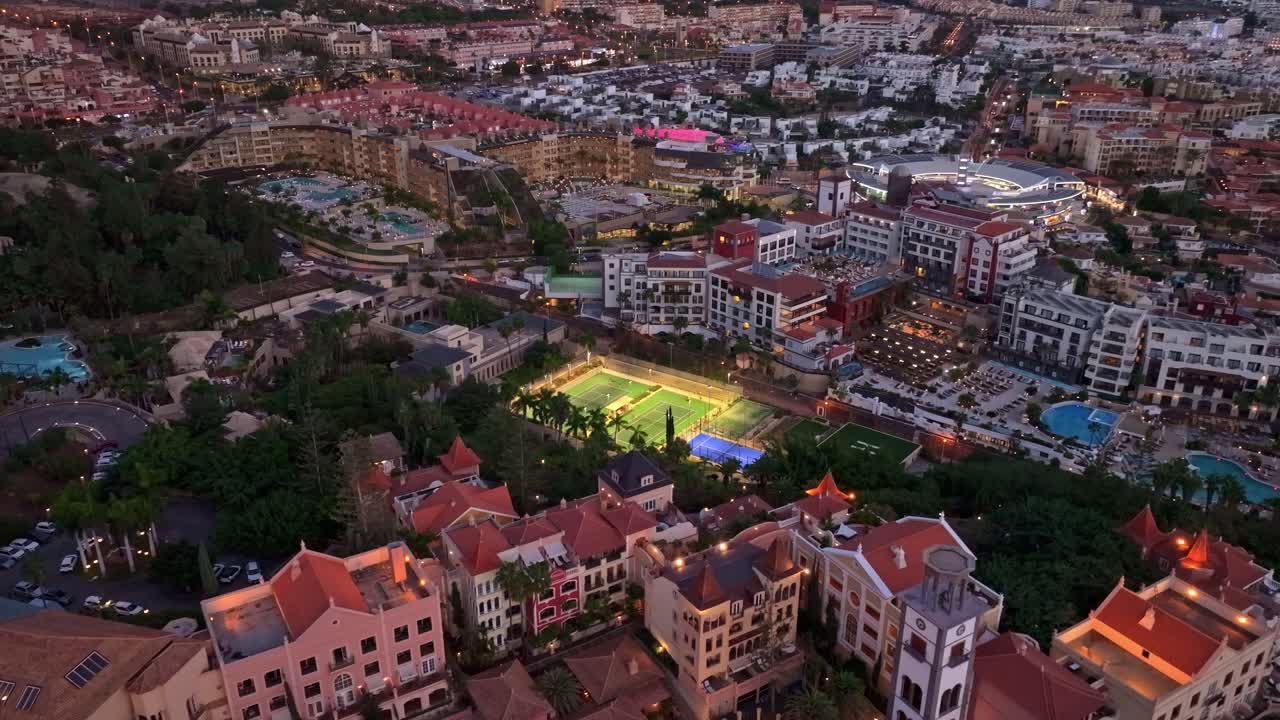Lush Costa Adeje resort in Tenerife at dusk with glowing tennis and sport fields
