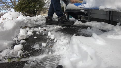 hombre paleando nieve frente a su casa, limpiando una gruesa capa de nieve