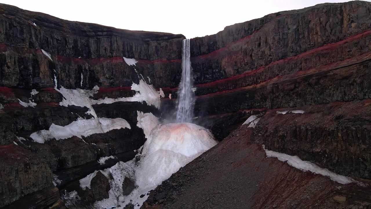 Flygbilder av vattenfallet Hengifoss på Island under vintern