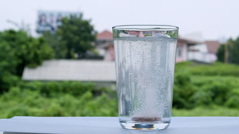 dejar caer una tableta de antiácido en un vaso de agua que estalla en pequeñas burbujas en el agua