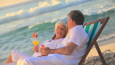 Älteres-Paar-Trinkt-Cocktails-Am-Strand