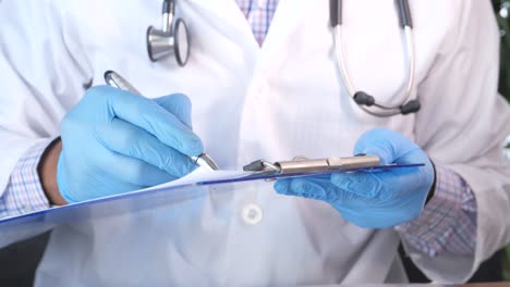 doctor writing on a medical record