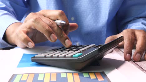 businessperson calculating on calculator