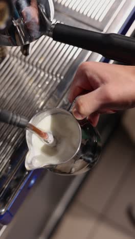 barista vaporizando leche para una bebida de café