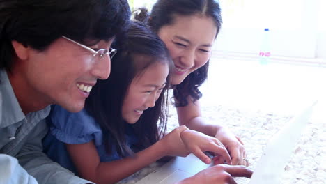 family laughing while using a laptop