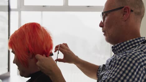 side view woman having her hair styled by a hairdresser