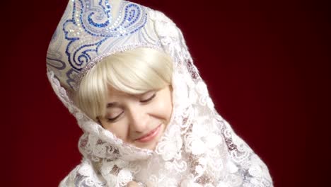 beautiful young woman in snow maiden costume is posing on the camera