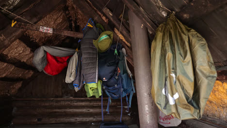 Chaqueta-De-Camping,-Mochilas-Y-Colchonetas-Para-Dormir-Colgadas-Dentro-Del-Cobertizo-De-Secado