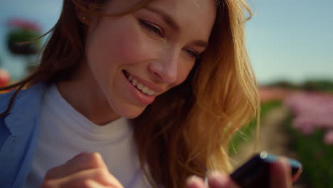 happy girl sliding cellphone screen outside. emotional girl communicating online