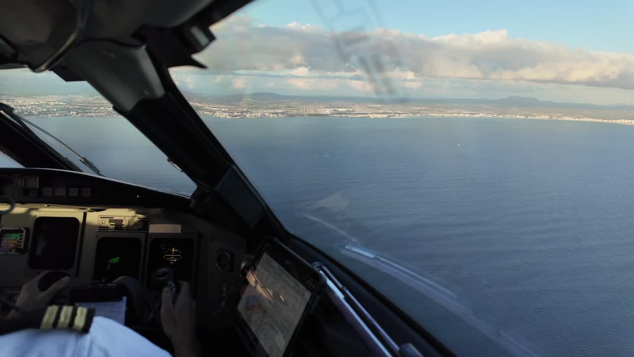 An immersive pilot view (Copilot Seat) in a real time approach to Palma de Mallorca airport, overflying the Mediterranean Sea with the runway ahead. Copilot is flying the jet. Daylight with few clouds