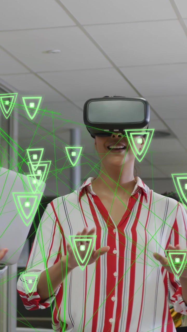 Vertikální video: Žena aktivuje VR headset a gestikuluje, pohybující se zelené trojúhelníky pro technologickou ukázku.