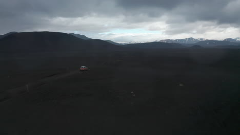 Drone-view-suv-offroad-in-Lakagigar-black-volcanic-desert-in-Iceland-Skaftafell-national-park.-Birds-eye-4x4-vehicle-speeding-on-black-lava-terrain-in-icelandic-highlands.-Adventure-and-exploration