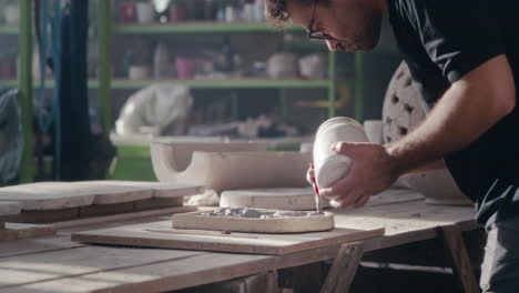 sculptor pouring clay into mold