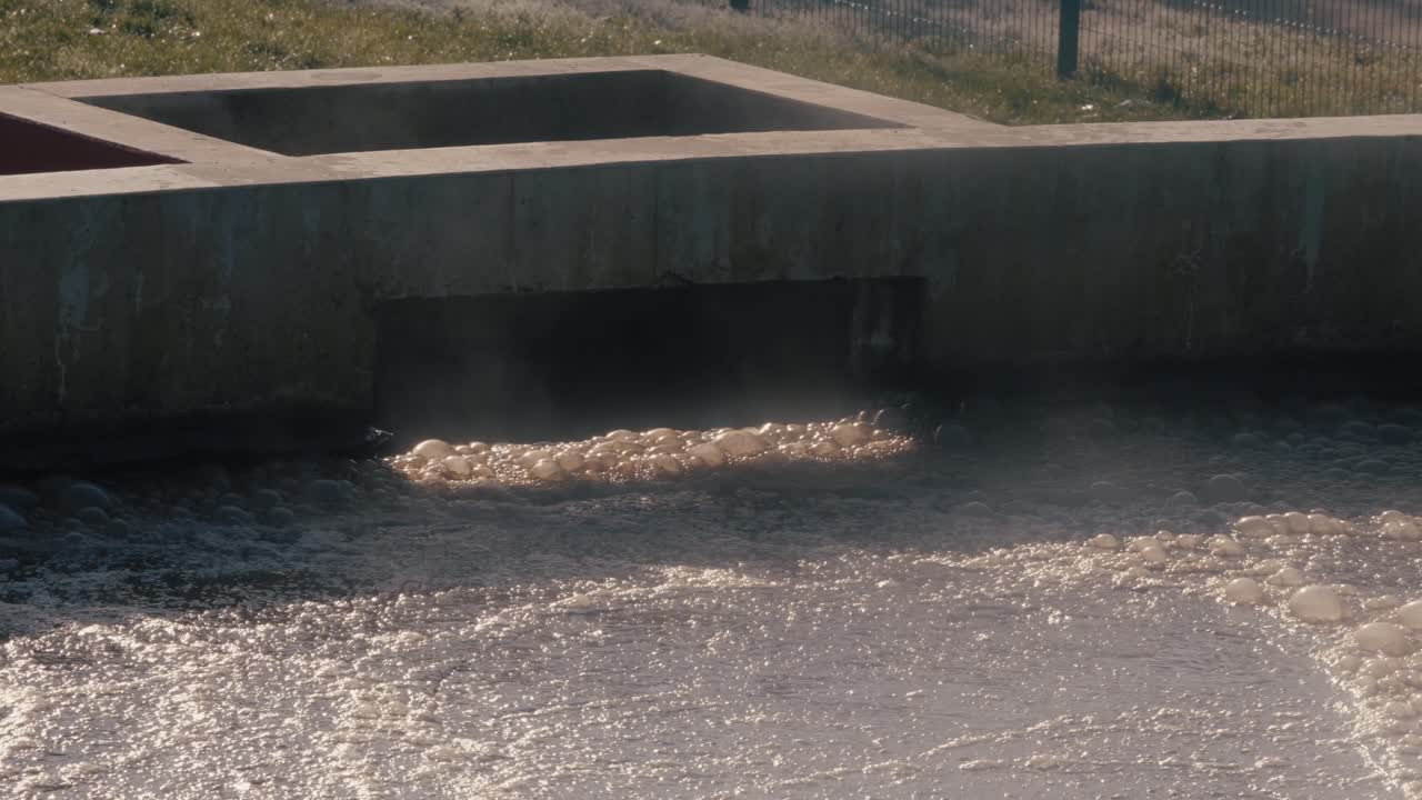 Aeration in wastewater basin, symbolizing purification, industrial setting, cool tones.