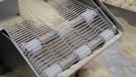 experimenta la dulzura automatizada: un primer plano captura una máquina hábilmente elaborando deliciosas golosinas en la pastelería