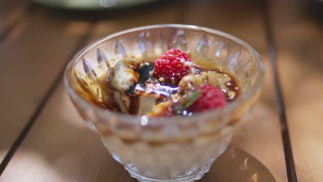 closeup berries caramel dessert glass plate at summer cafe. tasty sweet mousse