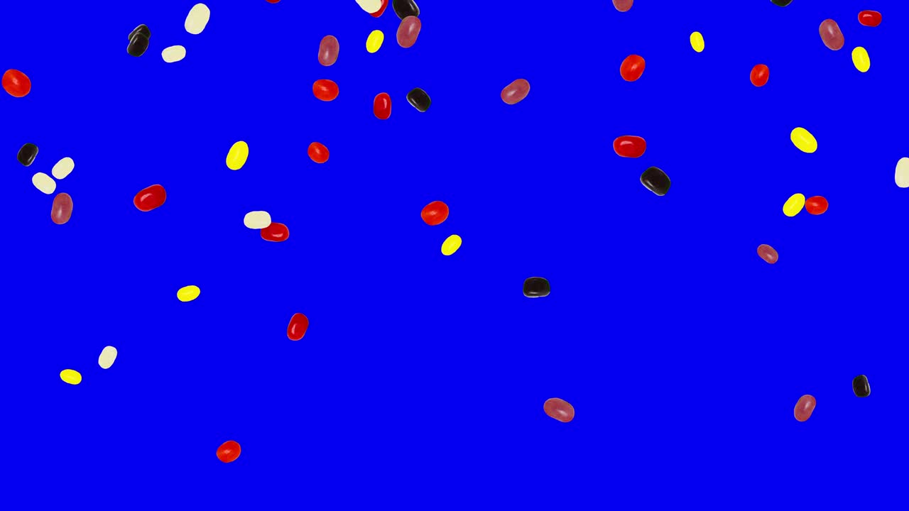 파란 스크린 배경에 회전하는 젤리 콩이 떨어집니다.