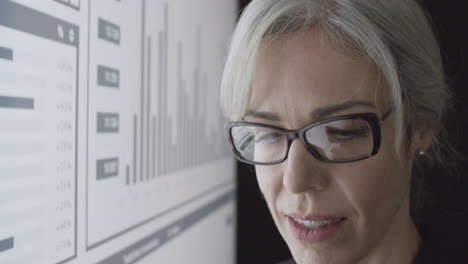 satisfied female trader smiling while analyzing financial report