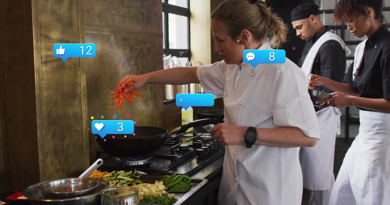 Vertical video: Adding carrots, lead chef in white coat stirring wok at stove, drawing social likes