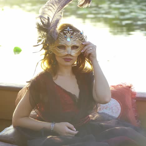 hermosa mujer con máscara de carnaval en góndola, venecia, italia.