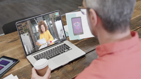 Caucasian-businessman-on-laptop-video-call-with-african-american-female-colleague-on-screen