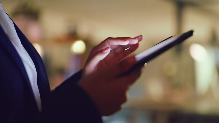 Donna d'affari che usa un tablet in un ristorante di notte