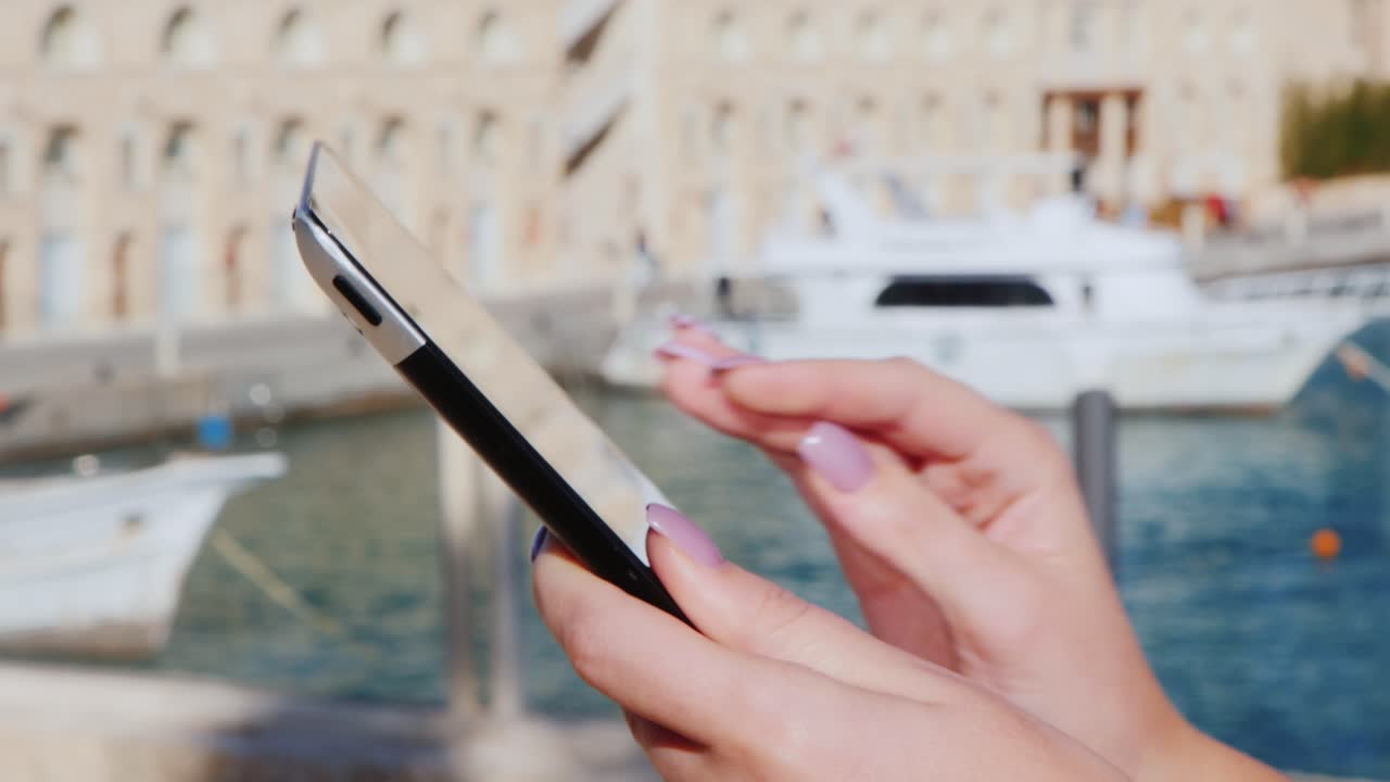 manos con la tableta en el fondo de los yates