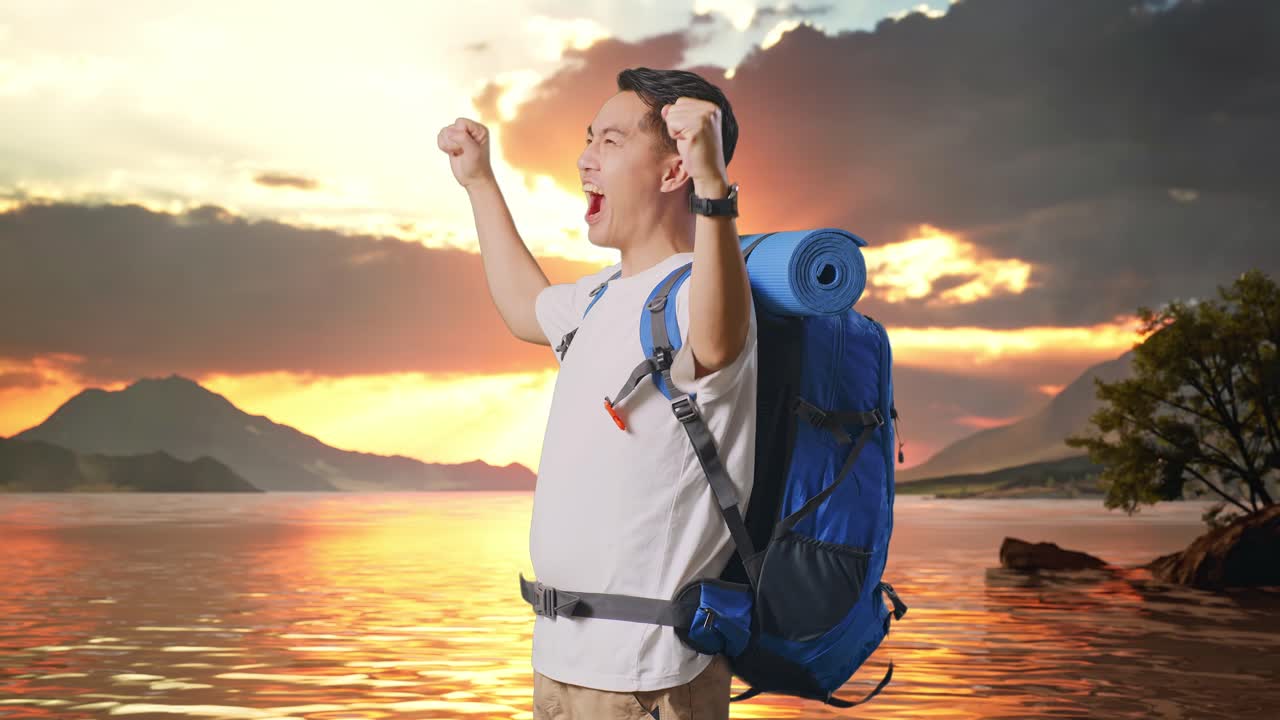 vista lateral de un excursionista masculino asiático con una mochila de montañismo gritando meta celebrando el éxito en un lago