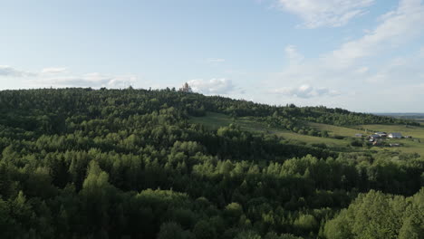 vista panorámica de una iglesia en la cima de una colina con el bosque y el pueblo circundantes