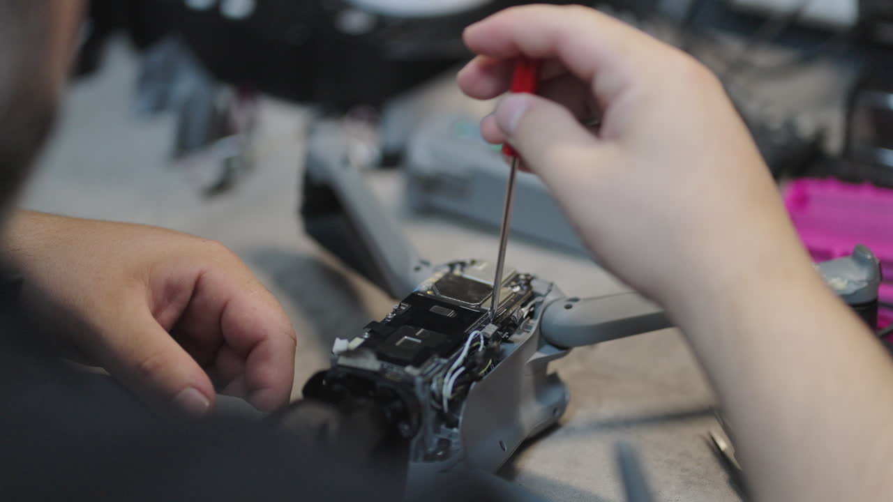 Close-up of skilled technician Repairing a Drone with Precision Tools. Maintenance and Technology.