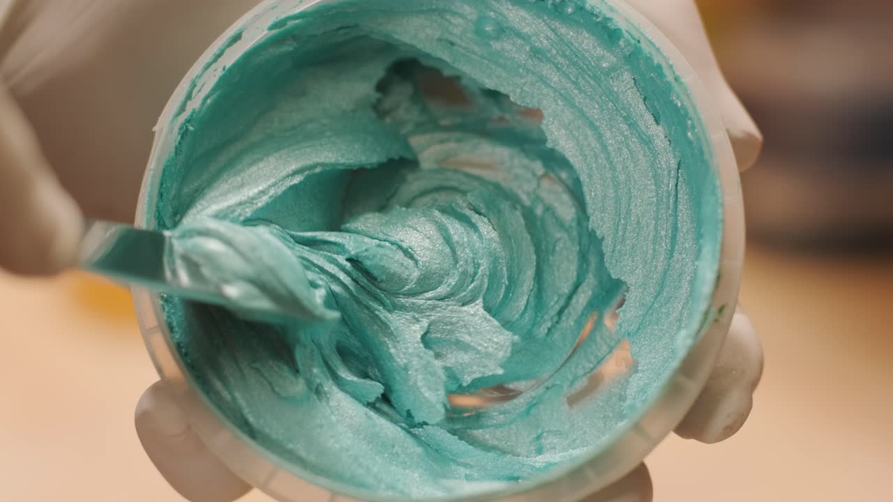 un trabajador mezcla el material para enmascarar las paredes