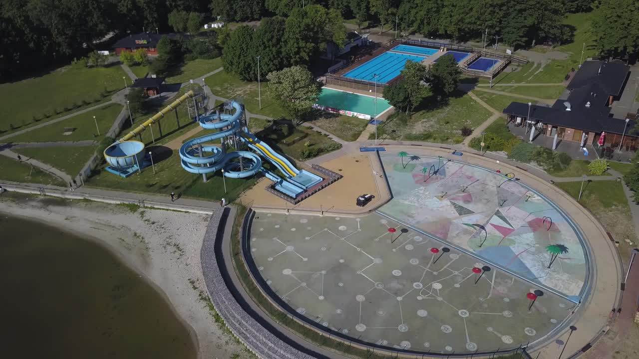 Aerial shot with tilt down of a water park near a lake in Poland.