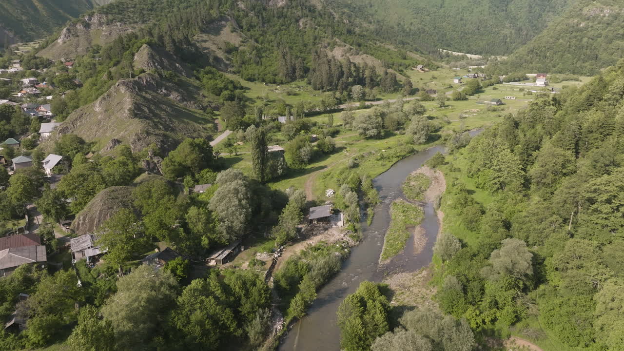 Ripresa aerea da drone dell'idilliaca città di Daba con un paesaggio montano boscoso sullo sfondo in Georgia