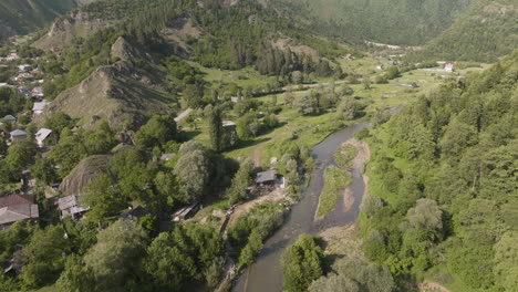 aerial view of idyllic daba town with forested mountainscape at background in georgia - drone shot