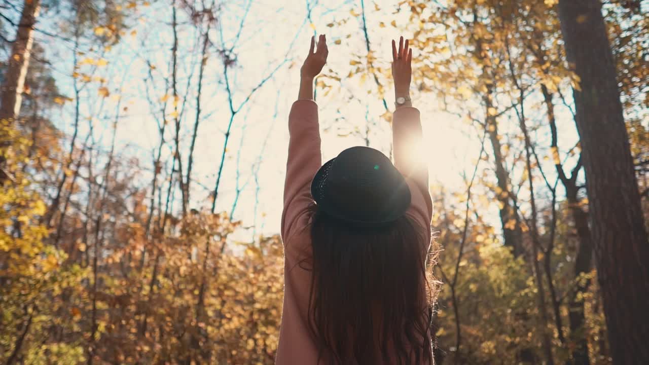 una mujer disfrutando del otoño en un bosque.