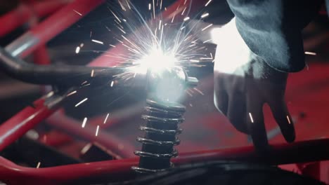 chispas brillantes que salen de la soldadura de metales juntos en el taller, de cerca
