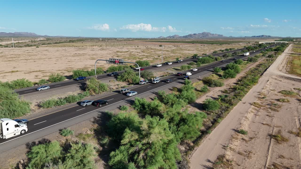 minor car accident on road as cars slowly drive by in the desert, Interstate 10 south of Phoenix Arizona, sunny day, blue skies, few clouds, mountain in background, congested traffic