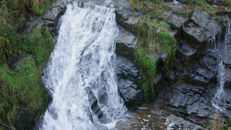 Una-Hermosa-Cascada-En-Cámara-Lenta-Con-Agua-Moviéndose-Sobre-Las-Rocas-De-Un-Río-Hacia-Una-Piscina-De-Rocas