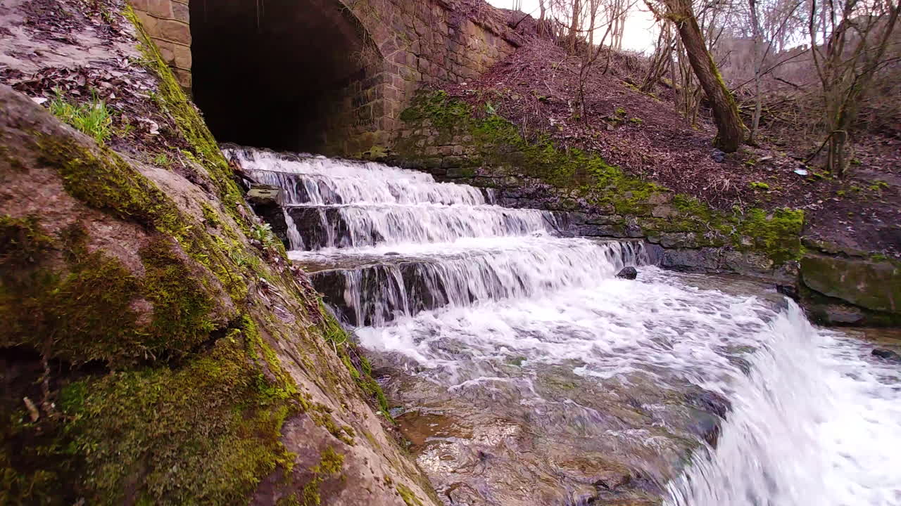 hermosa cascada de agua en marvele debajo del puente, vista trasera de dolly