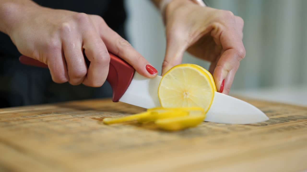 Female hands cutting fresh juicy lemon on a wooden kitchen board. Healthy lifestyle. Fresh fruits.
