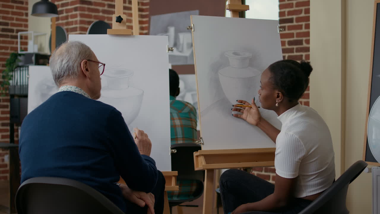 Woman explaining to senior man how to draw model on canvas